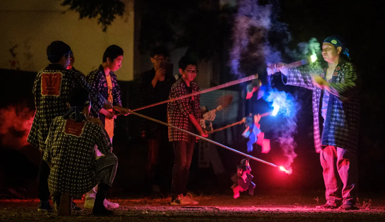 Sejumlah pria menyalakan Tezutsu hanabi atau kembang api genggam pada malam Festival Toyohashi Gion di Toyohashi, Jepang, Jumat (20/7). Tradisi ini telah dipraktekkan selama lebih dari 350 tahun. (Yasuyoshi CHIBA/AFP)