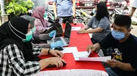 Petugas mendata warga saat vaksinasi COVID-19 keliling di Kebon Kacang, Jakarta, Jumat (9/7/2021). Pemerintah Provinsi DKI Jakarta meluncurkan 16 mobil vaksin COVID-19 keliling guna mempercepat pencapaian target vaksinasi COVID-19 di Ibu Kota. (Liputan6.com/Faizal Fanani)