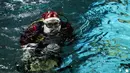 Aquarist Volmer Salvador bersiap berenang dalam akuarium AquaRio mengenakan kostum Sinterklas saat musim Natal di Rio de Janeiro, Brasil, 20 Desember 2021. Dengan luas bangunan sekitar 26.000 meter persegi, AquaRio dianggap sebagai akuarium laut terbesar di Amerika Selatan. (AP Photo/Bruna Prado)