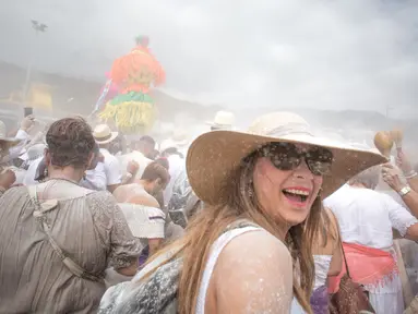 Orang-orang yang berselimut bedak ambil bagian dalam karnaval jalanan 'Los Indianos' di Santa Cruz de la Palma, Spanyol, Senin (4/3). Karnaval ini  bagian dari rangkaian acara yang diadakan sejak Januari hingga Februari tiap tahunnya. (DESIREE MARTIN/AFP)