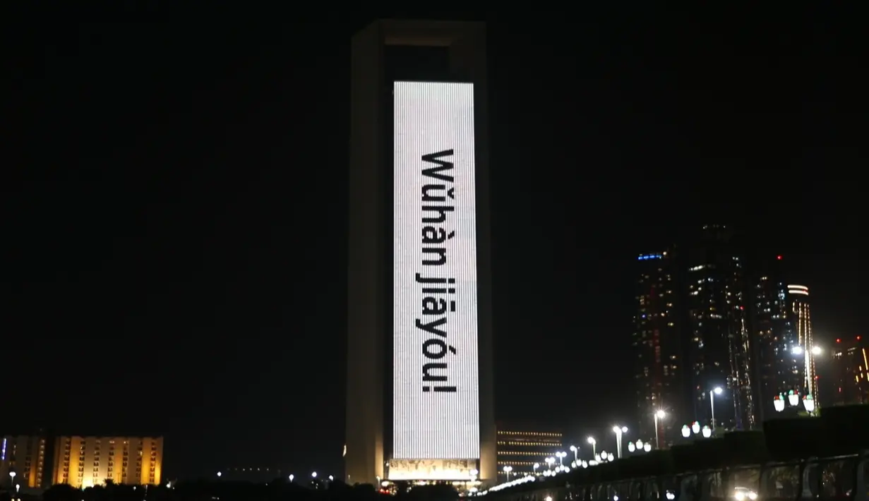 Bangunan Perusahaan Minyak Nasional Abu Dhabi (ADNOC) diterangi dengan slogan-slogan 'Wuhan jiayou' yang berarti 'Wuhan, semangat' di Abu Dhabi, Uni Emirat Arab (UEA), Minggu (2/2/2020). Hal tersebut untuk memberi semangat kepada China dalam perang melawan virus corona. (Xinhua/WAM)