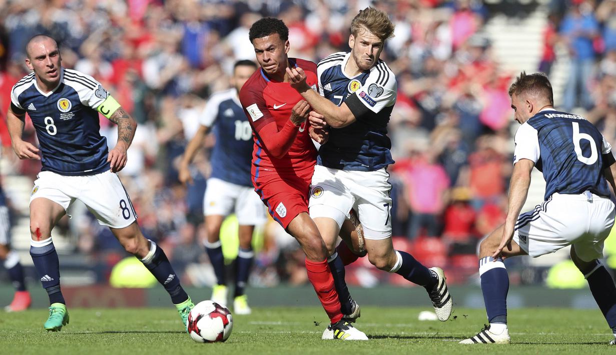 Gelandang Inggris, Dele Alli, berebut bola dengan gelandang Skotlandia, Stuart Armstrong pada kualifikasi Piala Dunia 2018 di Hampden Park, Sabtu (10/6/2017). Skor berakhir imbang 2-2. (AP/Scott Heppell)