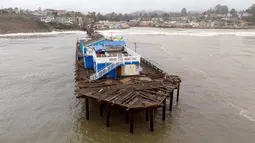 Pemandangan udara menunjukkan dermaga yang rusak terbelah di Capitola, California, pada 9 Januari 2023. Badai besar yang disebut "badai bom" oleh ahli meteorologi telah tiba dan diperkirakan akan menyebabkan banjir yang meluas di seluruh negara bagian. (AFP/Josh Edelson)