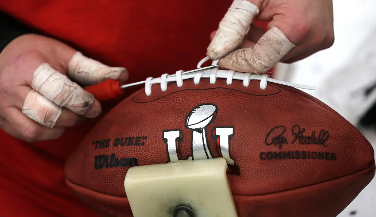 Pekerja mengikat bola American Football yang akan digunakan untuk NFL Super Bowl LI di pabrik di Wilson Sporting Goods di  Ada, Ohio, AS (23/1). (AP Photo/Charles Rex Arbogast)