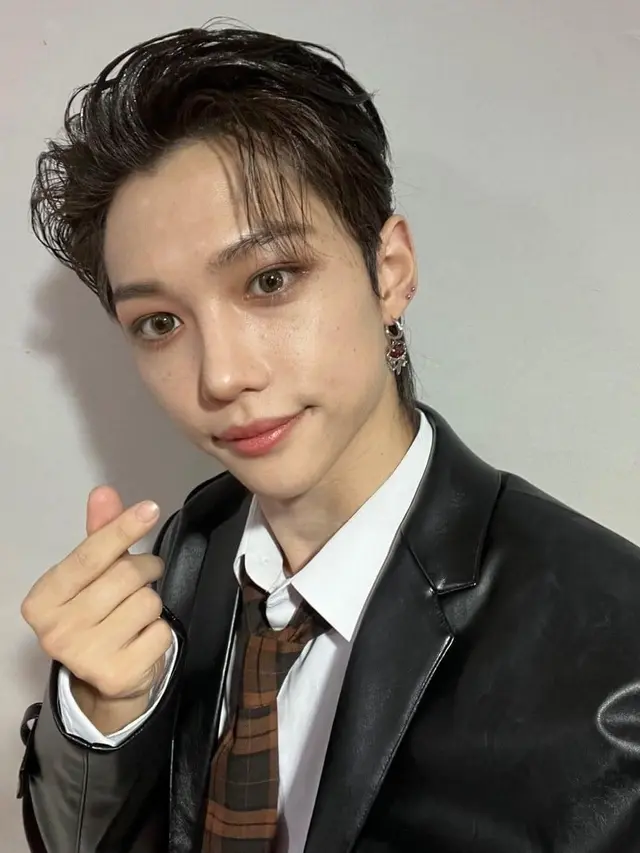 Potret Felix STRAY KIDS dengan Pose Finger Heart