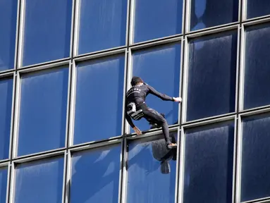 Alain Robert atau juga dikenal dengan nama 'Spiderman Prancis' memanjat gedung di pusat bisnis La Defense, Paris, Prancis, Rabu (14/3). Meski sudah menginjak usia 55 tahun, Alain masih melakukan hobi ekstremnya itu. (AP Photo/Francois Mori)