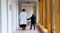 Seorang dokter yang sedang membimbing salah satu anak berjalan di lorong Rumah Sakit Ecole di Neuilly-Plaisance, dekat Paris, 21 Maret 2017. Rumah sakit yang khusus untuk anak penderita autis ini baru saja dibuka untuk umum. (BERTRAND GUAY/AFP)