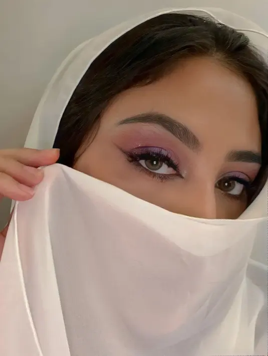 Sekali lagi melihat Margin Wieheerm yang luar biasa cantik bak putri Arab. Tapi kali ini, ia memilih kerudung berwarna putih dan menutupi sebagian wajahnya. Margin hanya menampilkan riasan matanya yang tajam dengan winged-eyeliner dan sedikit semburat warna merah muda. Foto: Instagram.
