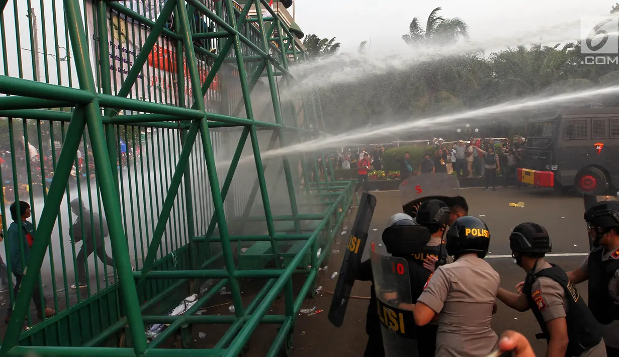 Polisi menembakkan air menggunakan water cannon ke arah mahasiswa saat demonstrasi menolak pengesahan RUU KUHP dan revisi UU KPK di depan Gedung DPR, Jakarta, Selasa (24/9/2019). Polisi menghalau mahasiswa yang berusaha masuk ke area Gedung DPR. (Liputan6.com/JohanTallo)