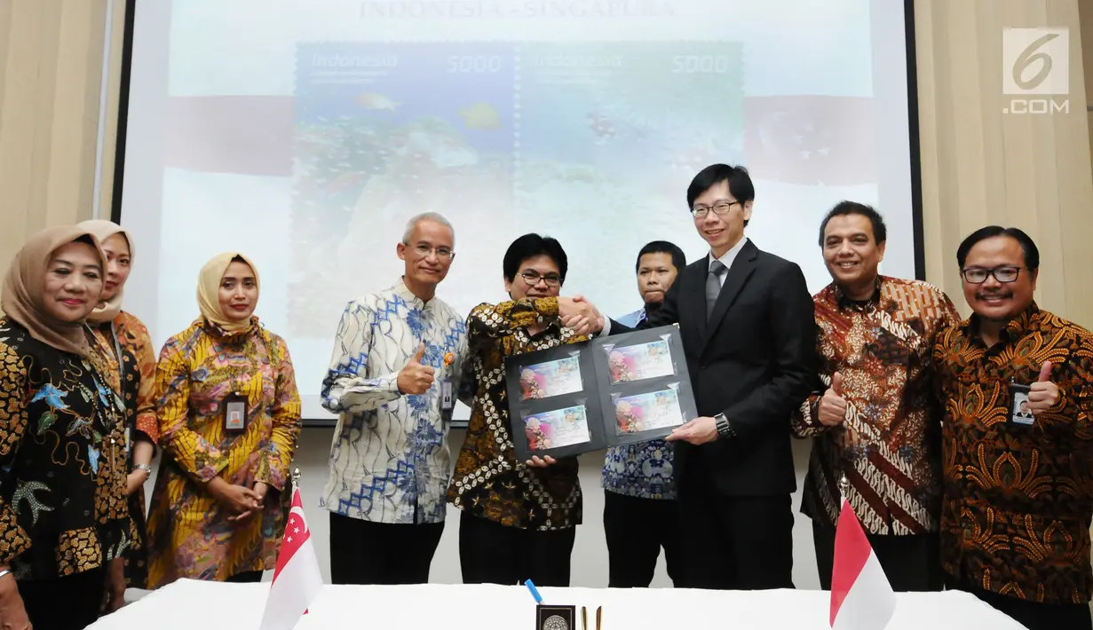 Dirjen Penyelenggaraan Pos dan Informatika, M Ramli (keempat kiri) menyerahkan cenderamata kepada Director of Mission Singapore, Jonathan Han usai penandatanganan dan peluncuran perangko bersama di Jakarta, Kamis (7/9). (Liputan6.com/Helmi Fithriansyah)