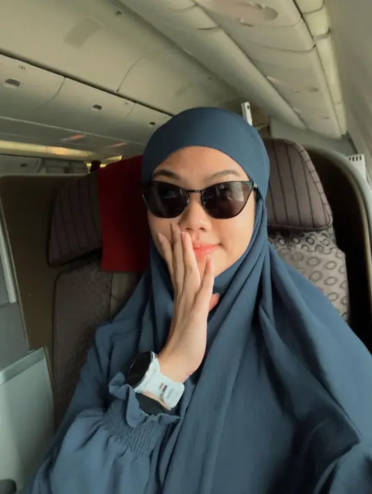 Saat berangkat, Yura mengenakan khimar warna navy, lengkap dengan kacamata hitamnya. [@yurayunita]