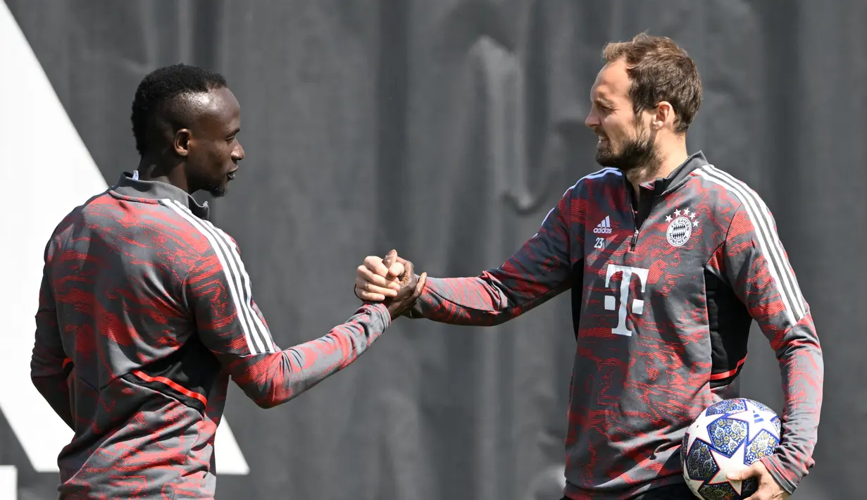 Bek Bayern Munchen Daley Blind (kanan) menyambut rekan setimnya Sadio Mane (kiri) pada awal sesi latihan menjelang perempat final Liga Champions menghadapi Manchester City di Munich, Jerman bagian selatan, Senin (10/4/2023). (Photo by Christof STACHE / AFP)