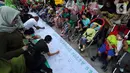 Masyarakat dan relawan menandatangani spanduk saat memperingati Hari Cerebral Palsy Sedunia di area Car Free Day, Jakarta, Minggu (13/10/2019). Peringatan yang jatuh 6 Oktober itu dimanfaatkan untuk mensosialisasikan dan menggalang kepedulian bagi penyandang cerebral palsy (Liputan6.com/Johan Tallo)