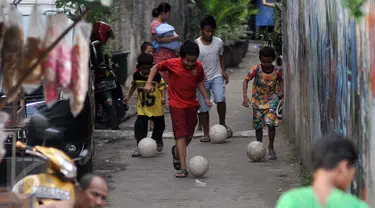 Sejumlah anak bermain bola di gang kecil kawasan Benhil, Jakarta, Rabu (10/6/2015). Anak-anak ini memanfaatkan gang kecil untuk bermain bola dikarenakan kurangnya sarana bermain khususnya lapangan bola di Jakarta. (Liputan6.com/Johan Tallo)