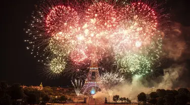 Kembang api menerangi Menara Eiffel selama perayaan Hari Bastille di Paris, Kamis (14/7/2022) malam. Perayaan yang digelar setiap tanggal 14 Juli ini dalam rangka untuk memperingati penyerbuan benteng penjara Bastille pada 14 Juli 1789 silam. (AP Photo/Lewis Joly)