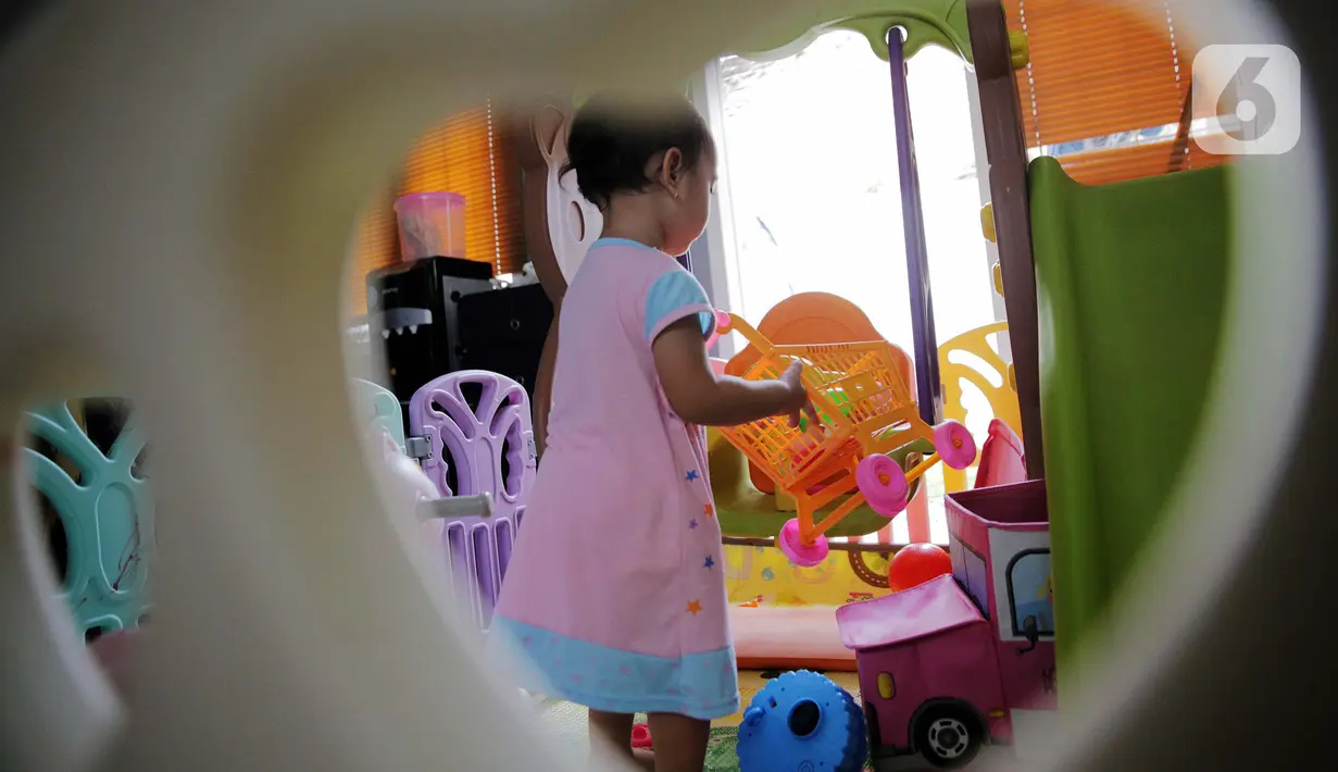 Seorang anak bermain di dalam rumah di Kawasan Jakarta, Minggu (29/3/2020). Aktivitas bermain di dalam rumah saat ini menjadi alternatif warga dalam mengurangi interaksi sosial sebagai upaya pencegahan penyebaran virus corona atau COVID-19. (Liputan6.com/Faizal Fanani)
