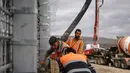 Sementara Lebanon dan Perserikatan Bangsa Bangsa (PBB) menganggap pembangunan di luar Garis Biru sebagai pelanggaran wilayah. Tampak dalam foto, pekerja Israel sedang menuangkan beton saat bekerja di pagar perbatasan yang memisahkan Israel utara dari Lebanon selatan pada 16 November 2025. (Jalaa MAREY/AFP)