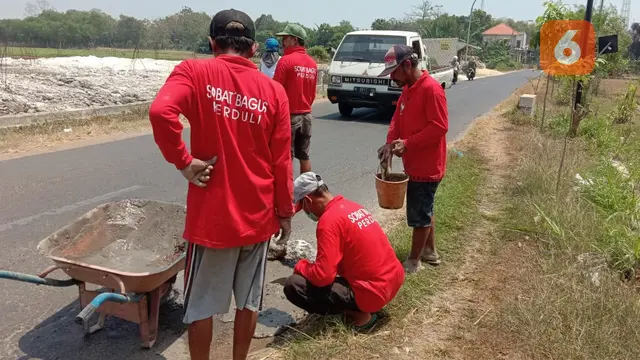 Menambal jalan berlubang
