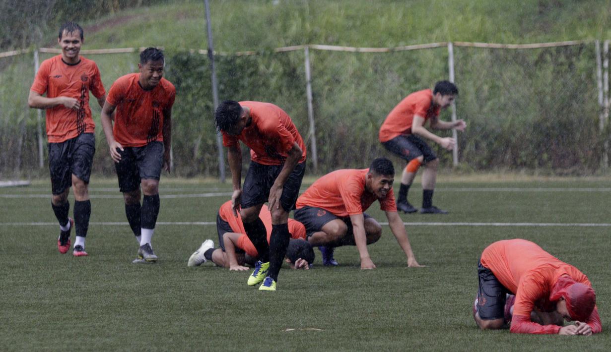 Pemain Persija Jakarta tampak tiarap saat ada petir di Lapangan NYTC, Sawangan, Depok, Kamis (16/1/2020). Hujan deras beserta petir membuat latihan Persija Jakarta kali ini hanya berlangsung sekitar 25 menit. (Bola.com/M Iqbal Ichsan)