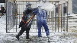 Seorang pria menaburkan tepung ke arah lawannya saat Festival Els Enfarinats di kota Ibi, Spanyol, Rabu (28/12). Festival tahunan Els Enfarinats memang selalu dirayakan dengan perang tepung dan telur. (AFP PHOTO / Jamie Reina)