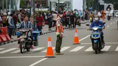Personel gabungan dari unsur polisi hingga Satpol PP mengatur lalu lintas di kawasan zebra cross Dukuh Atas, Jakarta, Rabu (27/7/2022). Mereka dikerahkan untuk memantau kegiatan peragaan busana Citayam Fashion Week (CFW) guna meminimalisir terjadinya kriminalitas, kemacetan, hingga parkir liar. (Liputan6.com/Faizal Fanani)