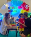 Arya Saloka pun hadir di ulang tahun anaknya. Ia mengenakan kaos hitam dipadukan celana pendek warna serasi dan topi capnya. [@anneofficial1990]