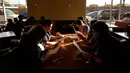 Pengunjung melihat menu yang disediakan di  Homegirl Cafe, Los Angeles, Senin (16/7). Kafe yang menyediakan sarapan dan makan siang khas Latin ini menawarkan pengalaman bersantap unik dengan mempekerjakan para mantan anggota geng. (AP/Jae C. Hong)