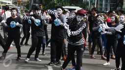 Aksi pantomim bersama saat memperingati World Mime Day 2017 di CFD, Jakarta, Minggu (19/3). Kegiatan ini diinisiasi oleh beberapa seniman dan komunitas pantomime di seluruh Indonesia. (Liputan6.com/Angga Yuniar)