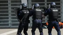 Petugas terlibat baku tembak saat melindungi warga sipil dalam latihan serangan teroris di Stadion Pierre Mauroy, Prancis (21/4). Latihan untuk mengantisipasi serangan teroris pada pertandingan sepak bola Euro 2016. (AFP PHOTO/DENIS Charlet)