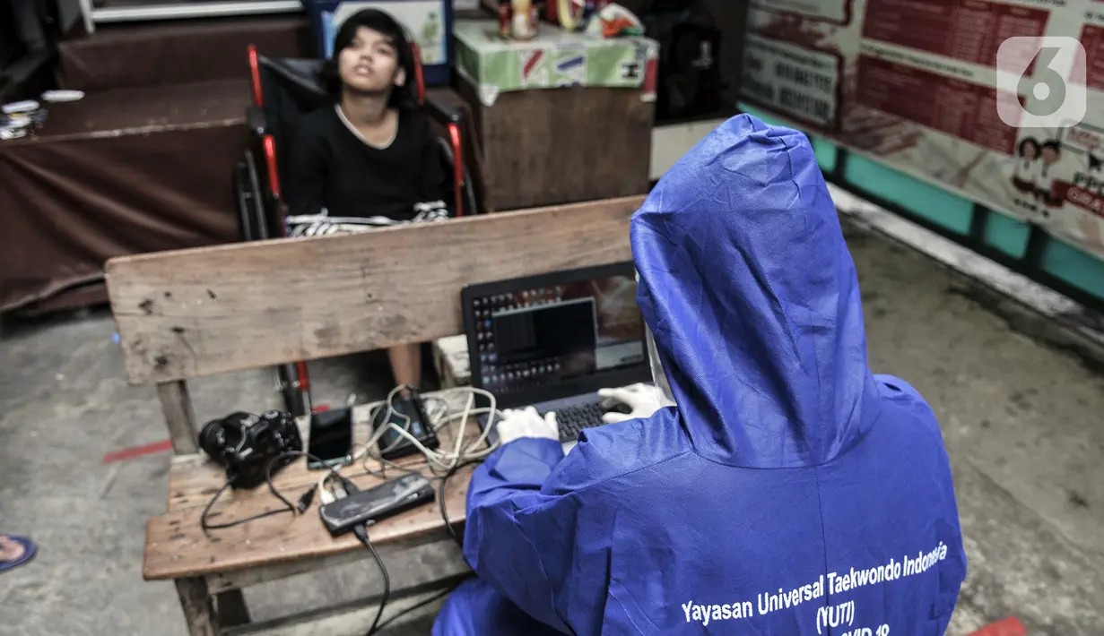 Petugas Disdukcapil Kota Jakarta Utara merekam E-KTP penyandang disabilitas di Pademangan Barat, Jakarta, Kamis (16/7/2020). Program jemput bola ini untuk memudahkan pelayanan administrasi kependudukan bagi penyandang disabilitas, jompo dan orang sakit di masa pandemi. (merdeka.com/Iqbal S. Nugroho)