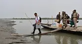 Seorang petugas pemilu membawa Mesin Pemungutan Suara Elektronik (EVM) ke sebuah tempat pemungutan suara dari sebuah kapal di Lohore Chapori di distrik Golaghat, di negara bagian Assam, India pada tanggal 18 April 2024. (Biju BORO/AFP)