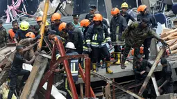 Petugas mencari korban yang tertimbun bangunan yang roboh di Kolombo, Sri Lanka, Kamis (18/5). Penyebab robohnya bangunan masih dalam tahap penyelidikan. (AFP/Ishara S. KODIKARA)