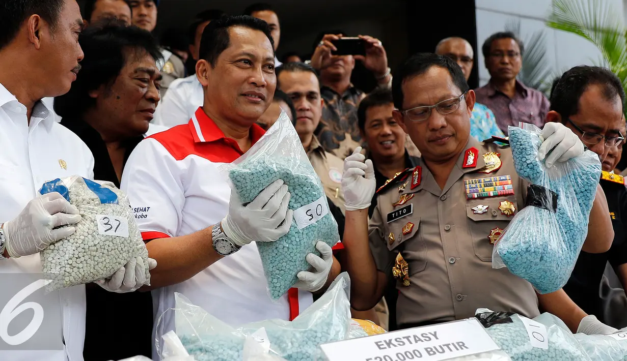 Kepala BNN, Komjen Budi Waseso (tengah) menunjukan barang bukti ekstasy saat rilis di Mapolda Metro Jaya, Jakarta, Rabu (7/10/2015).  47kg shabu dan 520 ribu butir ekstasy berhasil diamankan dari 4 orang tersangka. (Liputan6.com/Yoppy Renato)