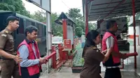 Petugas Kejari Kuansing menggiring dua tersangka korupsi pembangunan hotel ke Lapas untuk ditahan. (Liputan6.com/M Syukur)