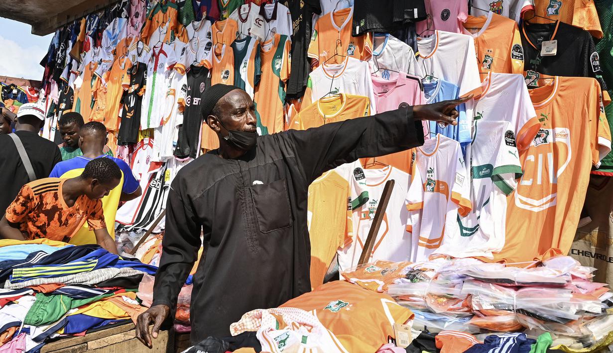 Seorang pedagang menunjukkan barang dagangannya di pasar menjelang Piala Afrika 2023 di Abidjan, Pantai Gading pada 6 Januari 2024 waktu setempat. (AFP/Issouf Sanogo)