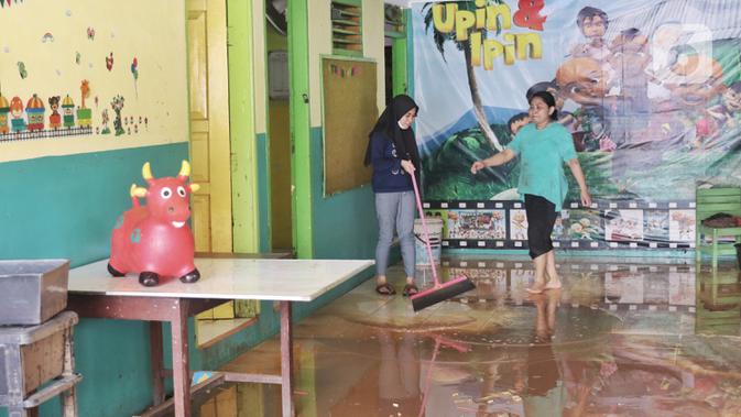 Warga membersihkan lumpur sisa pascabanjir di perumahan Ciledug Indah, Tangerang Senin (22/2/2021). Banjir yang menggenangi perumahan tersebut membuat warga mengalami kerugian cukup besar karena barang-barang berharga mereka rusak parah. (Liputan6.com/Angga Yuniar)