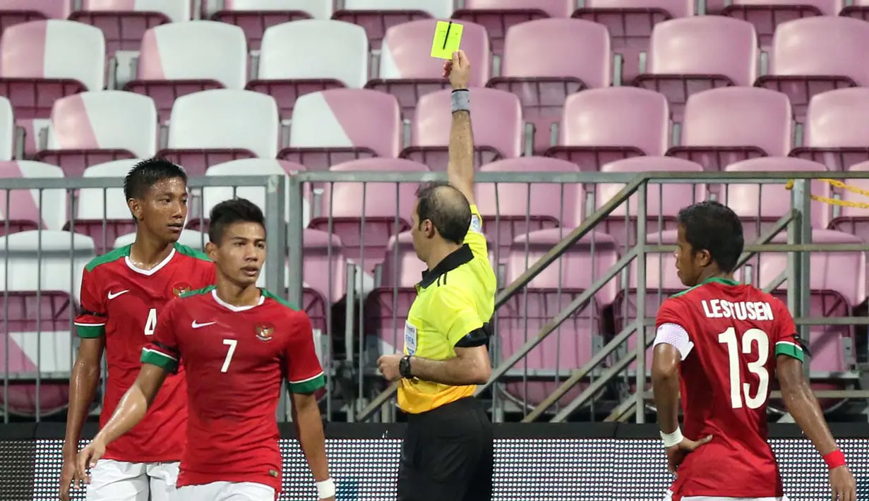 Wasit Turki Alkhudhayr memberi kartu kuning kepada Syaiful Indra Cahya (4) setelah melanggar pemain Kamboja U-23 di kotak penalti yang berbuah tendangan penalti bagi Kamboja U-23. (Bola.com/Arief Bagus)