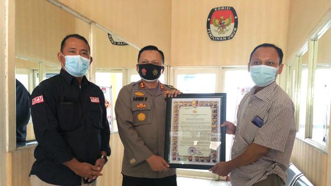 Kapolres Gresik AKBP Arief Fitrianto memberikan dokumen maklumat dari Kapolri kepada Ketua KPU Gresik Ahmad Roni. (Foto: Dok Istimewa)