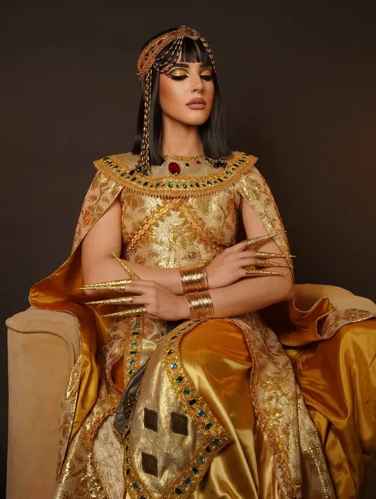 Eyeliner hitam ditarik tajam membentuk wing yang mencolok, dipadukan dengan semburat biru metalik di bawah mata, serta gradasi gold yang memperkuat kesan mewah. Detail ini bukan hanya mempertegas bentuk mata Tasya, tetapi juga memberi efek tajam dan tegas, ciri khas makeup Cleopatra yang ikonik. [@tasyafarasya].