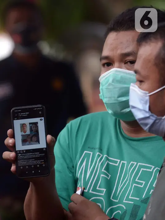 Keluarga menunjukkan foto korban jatuhnya pesawat Sriwijaya Air SJ 182 di Posko Ante Mortem-DVI RS Polri Jakarta, Selasa (12/1/2021). Hingga saat ini, tim DVI masi mengumpulkan sampel DNA penumpang pesawat Sriwijaya Air SJ 182 yang jatuh di perairan Kepualauan Seribu. (merdeka.com/Imam Buhori)