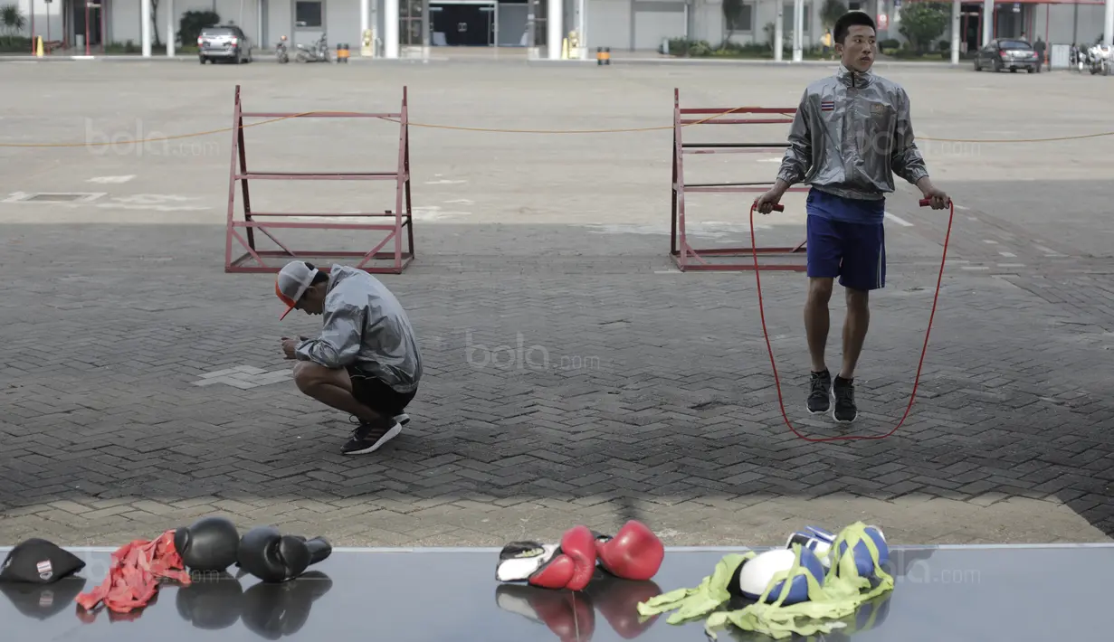Dua petinju Thailand santai melakukan pemanasan di Arena Hall D PRJ, Kemayoran, Jakarta, Minggu (11/2/2018). Tim tinju Thailand menjadi salah satu kekuatan yang perlu di waspadai Indonesia. (Bola.com/Nick Hanoatubun)