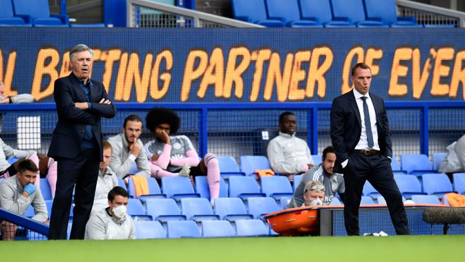 Pelatih Everton, Carlo Ancelotti (kiri) dan pelatih Leicester City Brendan Rodgers menyaksikan pemainnya bertanding pada pertandingan lanjutan Liga Inggris di di Goodison Park di Liverpool, Inggris, Rabu (1/7/2020). Everton menang tipis atas Leicester City 2-1. (Peter Powell / Pool via AP)
