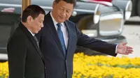 Presiden Filipona Rodrigo Duterte (kiir) berjalan berdampingan dengan Presiden China Xi Jinping (kanan) di Beijing. (AP/Ng Han Guan)
