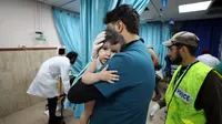 Petugas medis Palestina menggendong seorang anak yang terluka dalam serangan udara Israel terhadap Jalur Gaza di Deir el-Balah, Minggu (22/10/2023). (AP Photo/Ali Mahmoud)