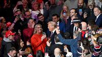 Usai resmi dilantik sebagai Presiden Amerika Serikat, Donald Trump bersama Ibu Negara Melania Trump menghadiri parade perdana di dalam Capital One Arena, Washington DC. (ANGELA WEISS/AFP)
