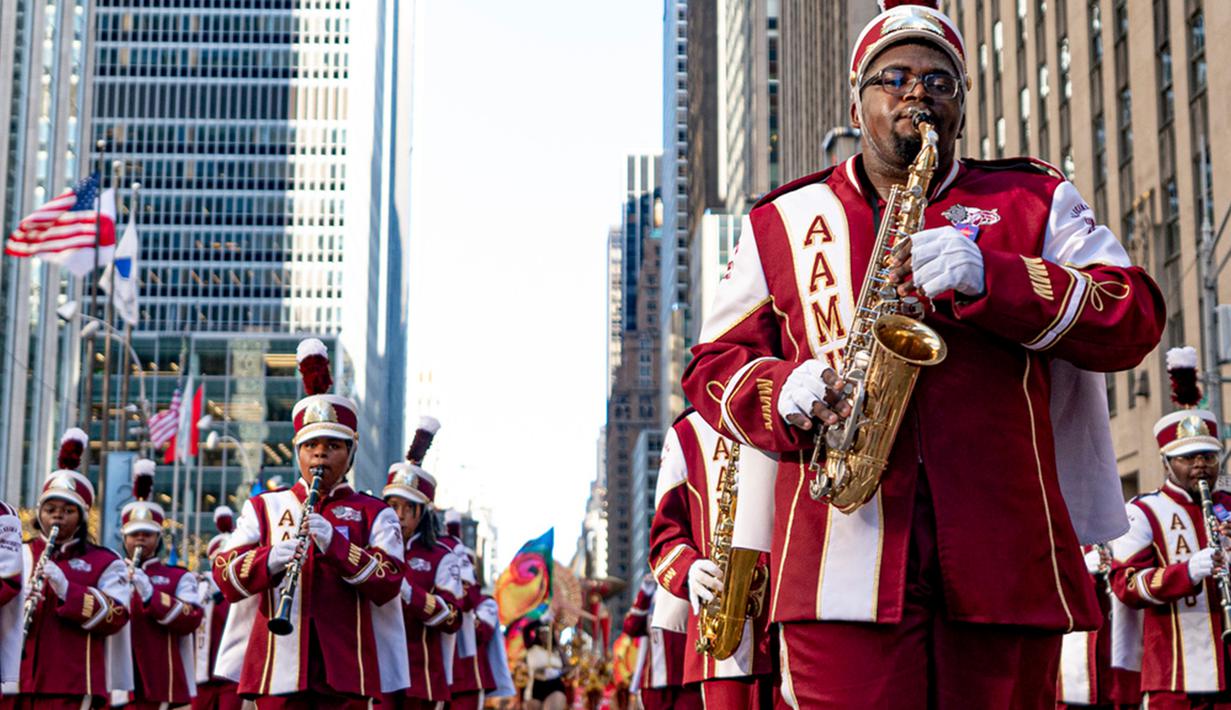 Berbagai karakter melintasi gedung pencakar langit kota pada Kamis keempat bulan November. (AP Photo/Peter K. Afriyie)