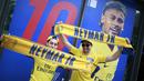 Fans berpose di depan gambar pemain baru Paris Saint Germain, Neymar Jr, di toko merchandise di Paris, Jumat (4/8/2017). Setelah resmi bergabung dengan Paris Saint Germain, jersey Neymar Jr langsung diburu suporter klub Ibu kota. (AFP/Benjamin Cremel)
