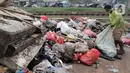 Warga memilah sampah sisa banjir yang menumpuk di kawasan Cipinang Melayu, Jakarta, Rabu (8/1/2020). Banjir yang melanda Jakarta dan sekitarnya sejak 1 Januari 2020 lalu menyisakan tumpukan sampah di sejumlah titik. (Liputan6.com/Herman Zakharia)
