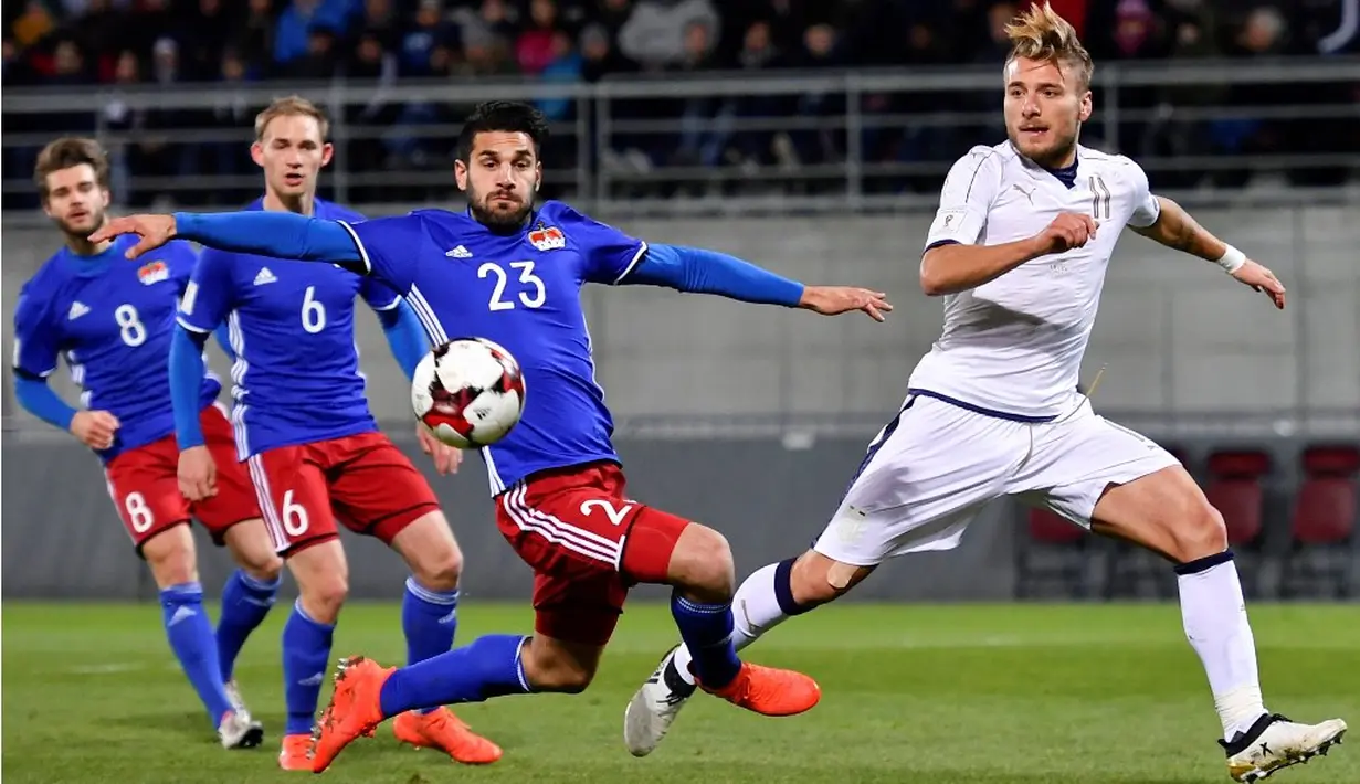 Pemain Italia, Ciro Immobile (kanan), berebut bola dengan pemain Liechtenstein, Michele Polverino, dalam laga Grup G Kualifikasi Piala Dunia 2018 di Stadion Rheinpark, Minggu (13/11/2016) dinihari WIB. (AFP/Fabrice Coffrini)
