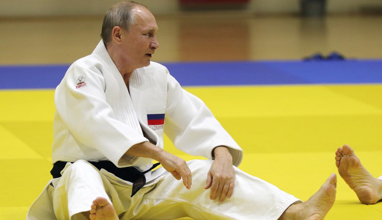 Presiden Vladimir Putin melakukan pemanasan sebelum mengikuti sesi latihan judo bersama atlet nasional Rusia di Sochi, Kamis (14/2). Judo merupakan salah satu olahraga kegemaran Putin yang telah digeluti sejak masa muda. (Mikhail KLIMENTYEV/SPUTNIK/AFP)